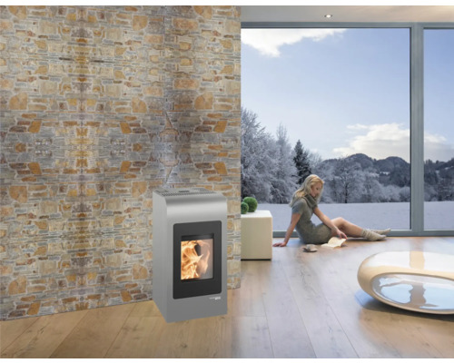 Wohnzimmer mit Pelletofen, Natursteinwand und Fenster mit Winterlandschaft