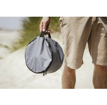 Graue, runde Tragetasche mit Reißverschluss in der Hand einer Person