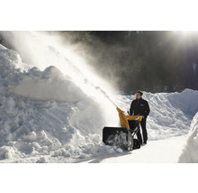 Mann benutzt eine Schneefräse zum Schneeräumen