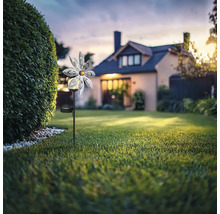 Gartenszene mit Blumensolarleuchte vor einem Wohnhaus