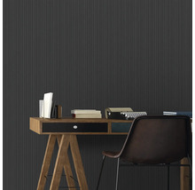 Arbeitszimmer mit Schreibtisch, Büchern, Schreibmaschine und geriffelter Wand