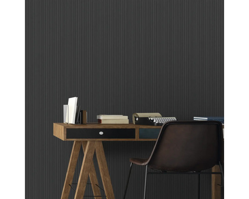 Arbeitszimmer mit Schreibtisch, Büchern, Schreibmaschine und geriffelter Wand