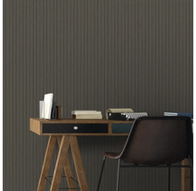 Bürobereich mit Schreibtisch, Büchern, Schreibmaschine und Stuhl vor einer Wand mit Holzpaneelen