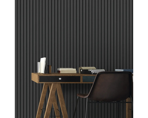 Szene mit Schreibtisch, Büchern, Schreibmaschine und Stuhl vor einer Wand mit Streifenmuster