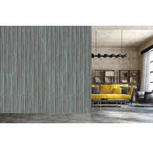 Wohnraum mit einer Wandtapete mit Holzstruktur hinter einem gelben Sofa.