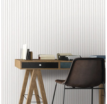 Arbeitszimmer mit Schreibtisch, Stuhl, Schreibmaschine und Büchern vor einer Tapete mit Streifenmuster