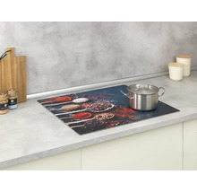 Glaskeramikfeldabdeckung mit Gewürzmuster und Kochtopf auf einer Küchentheke.