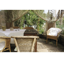 Dekorierter Gartentisch mit Rattan-Stühlen in heller, freundlicher Atmosphäre.