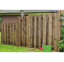 Holzzaun im Garten mit Rechen und Gartenkorb