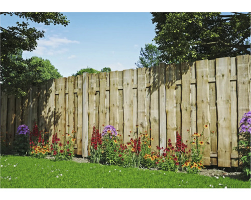Holzzaun mit Blumenbeet im Garten.
