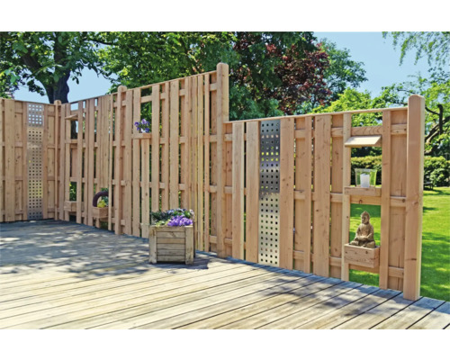 Holzzaun mit Pflanzkästen und Dekoration im Garten