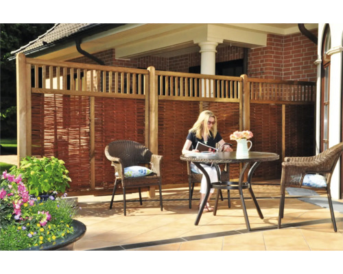 Sichtschutzzaun aus Holz und Weide mit Sitzgruppe im Garten