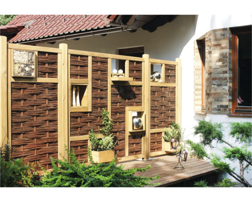Sichtschutzzaun aus Holz und Weide mit Dekorationselementen im Garten.
