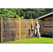 Naturzaun aus Weidenruten mit Frau und Fahrrad im Garten