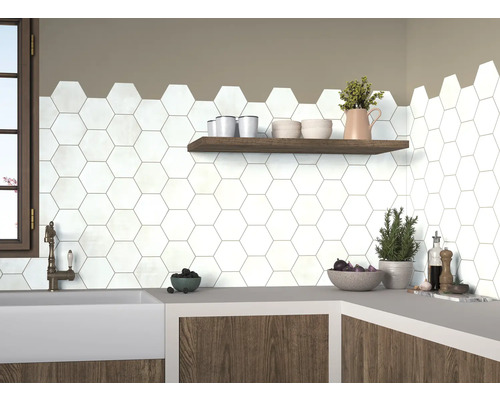 Küchenszene mit weißen, hexagonalen Fliesen an der Wand, ergänzt durch ein Holzregal und eine Arbeitsplatte