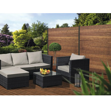 Gartenlounge-Set mit Sofa, Sessel und Tisch auf einer Terrasse vor einem Holzzaun