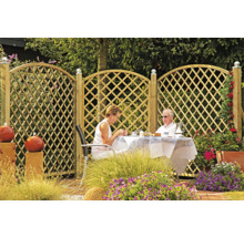 Holzzaun mit Rautenmuster im Garten mit sitzenden Personen