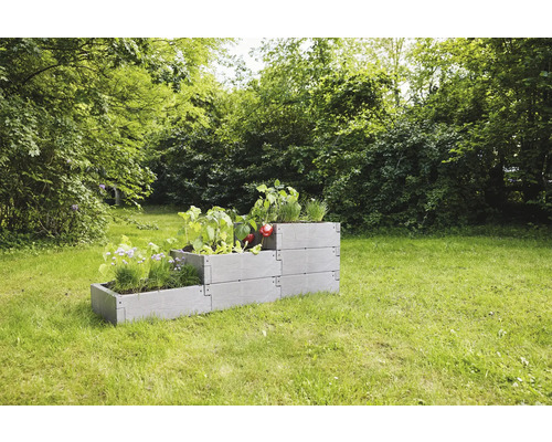 Hochbeet aus Kunststoff mit Bepflanzung im Garten
