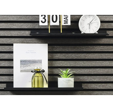 Dekorative Gegenstände auf einem Regal: Kalender, Uhr, Notizbuch, Duftflasche und Zimmerpflanze.