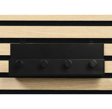 Schwarze Hakenleiste mit vier Haken vor einer Holzpaneelwand