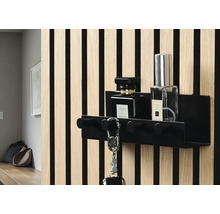 Schwarze Schlüsselablage mit Haken und zwei Parfümflaschen an einer Wand mit Holzverkleidung
