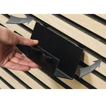 Nahaufnahme einer Person, die ein Regal an einer Holzlattenwand befestigt