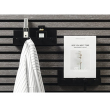 Schwarzes Wandregal mit Jacke, Parfüm und A4-Papier