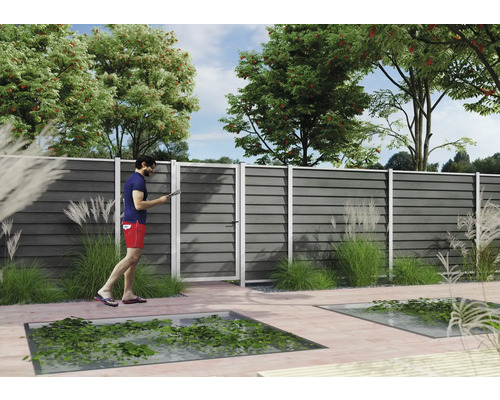 Moderner Sichtschutzzaun aus grauen horizontalen WPC-Lamellen mit passender Gartentür auf einer hellen Holzterrasse im Garten.