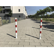 Zwei rot-weiss gestreifte Absperrpfosten auf einem Bürgersteig