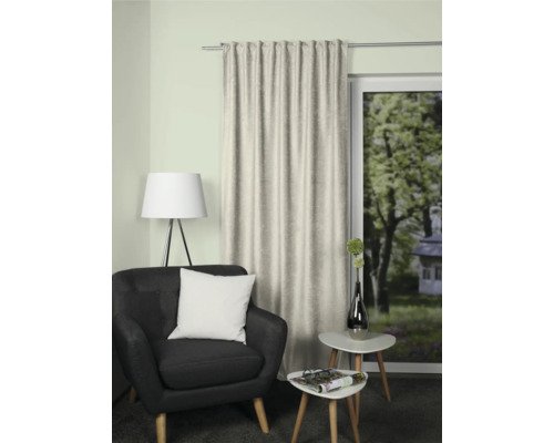 Wohnzimmer mit Sessel, Beistelltischen und Vorhang