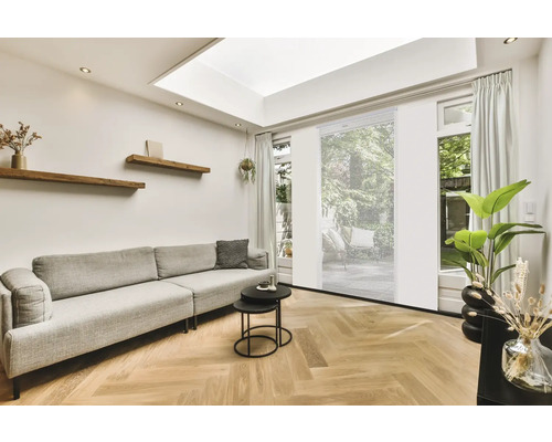 Wohnzimmer mit Sofa, Couchtisch, Holzregalen und Rollos