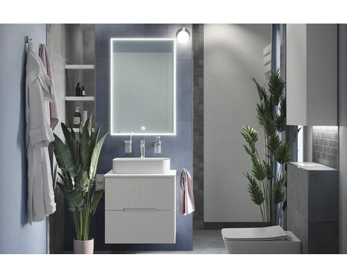 Modernes Badezimmer mit Waschtisch, Spiegel mit Beleuchtung und Toilette.