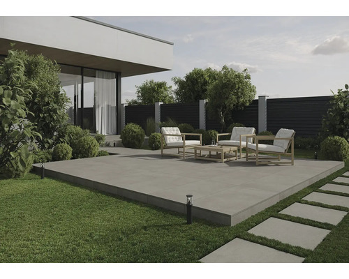 Terrasse mit Gartenmöbeln und Steinplatten in einem modernen Garten.