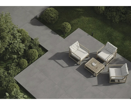 Terrasse mit grauen Fliesen, Gartenmöbeln und Grünpflanzen von oben