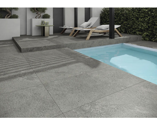 Außenbereich mit grauen Bodenfliesen, Pool und Liegestühlen