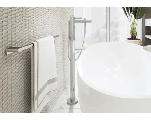 Helles Badezimmer mit Badewanne, Handtuchhalter und strukturierten Wandfliesen