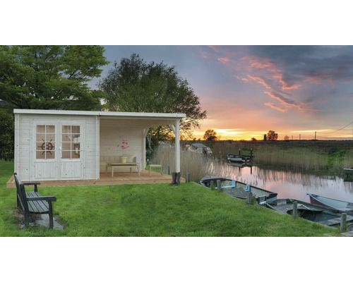 Gartenhaus aus Holz mit überdachter Veranda am See bei Sonnenuntergang.