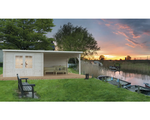 Holzgartenhaus mit Terrasse am See bei Sonnenuntergang.