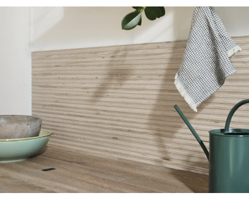 Küchenszene mit Arbeitsplatte, Wandpaneelen in Holzoptik, Geschirr und Gießkanne