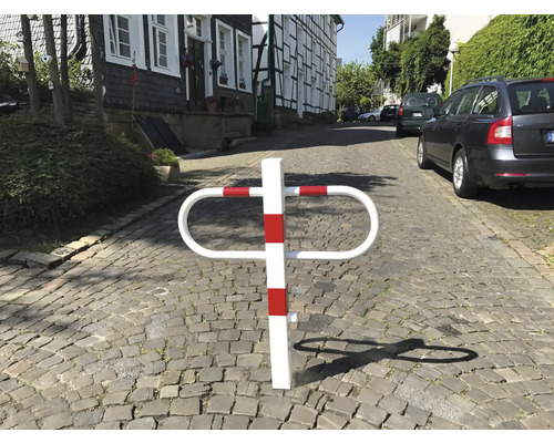 Parkplatzsperre mit rot-weißen Streifen auf Kopfsteinpflaster