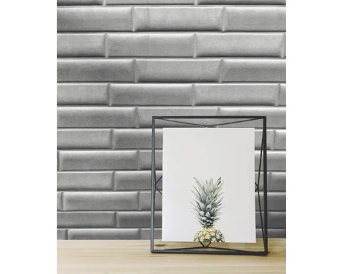 Wandfliesen im Metro-Stil als Hintergrund für einen Bilderrahmen mit Ananasdruck.