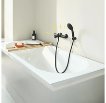 Badewanne mit schwarzer Duscharmatur und Ablage