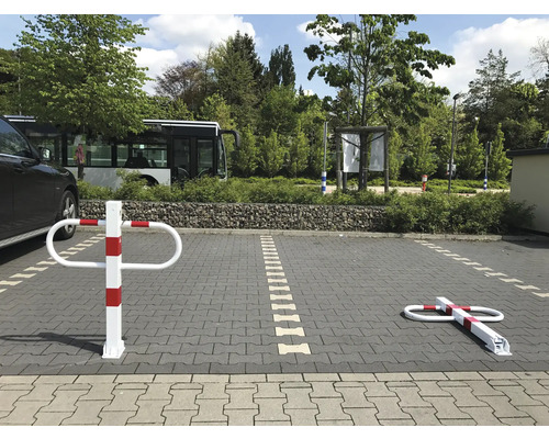 Parkplatz mit einem umklappbaren Sperrpfosten in aufrechter und umgeklappter Position