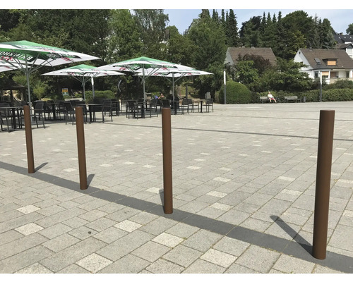 Platz mit Pollern, Tischen und Sonnenschirmen