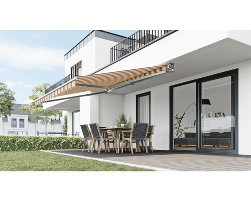 Terrasse mit Markise, Tisch und Stühlen vor einem modernen Haus.