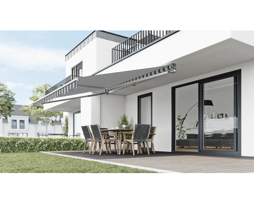 Terrasse mit Markise, Tisch und Stühlen vor einem modernen Haus