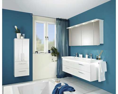 Modernes Badezimmer mit weißem Waschtisch, Spiegelschrank, Hochschrank und Badewanne vor blauer Wand