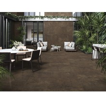 Terrasse mit Keramikfliesen in Braun, Gartenmöbeln und üppiger Bepflanzung