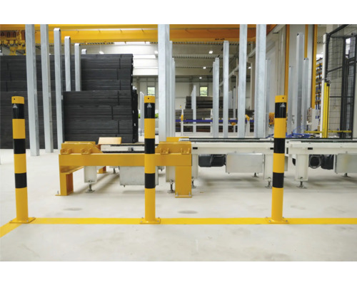 Industriehalle mit Warnmarkierungen und Materialstapeln