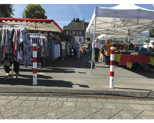 Szene eines Marktplatzes mit Kleiderständen und Besuchern